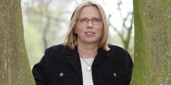 Annette Stettien guckt zwischen zwei Bäumen hindurch nach vorne. Copyright: Coaching Stettien